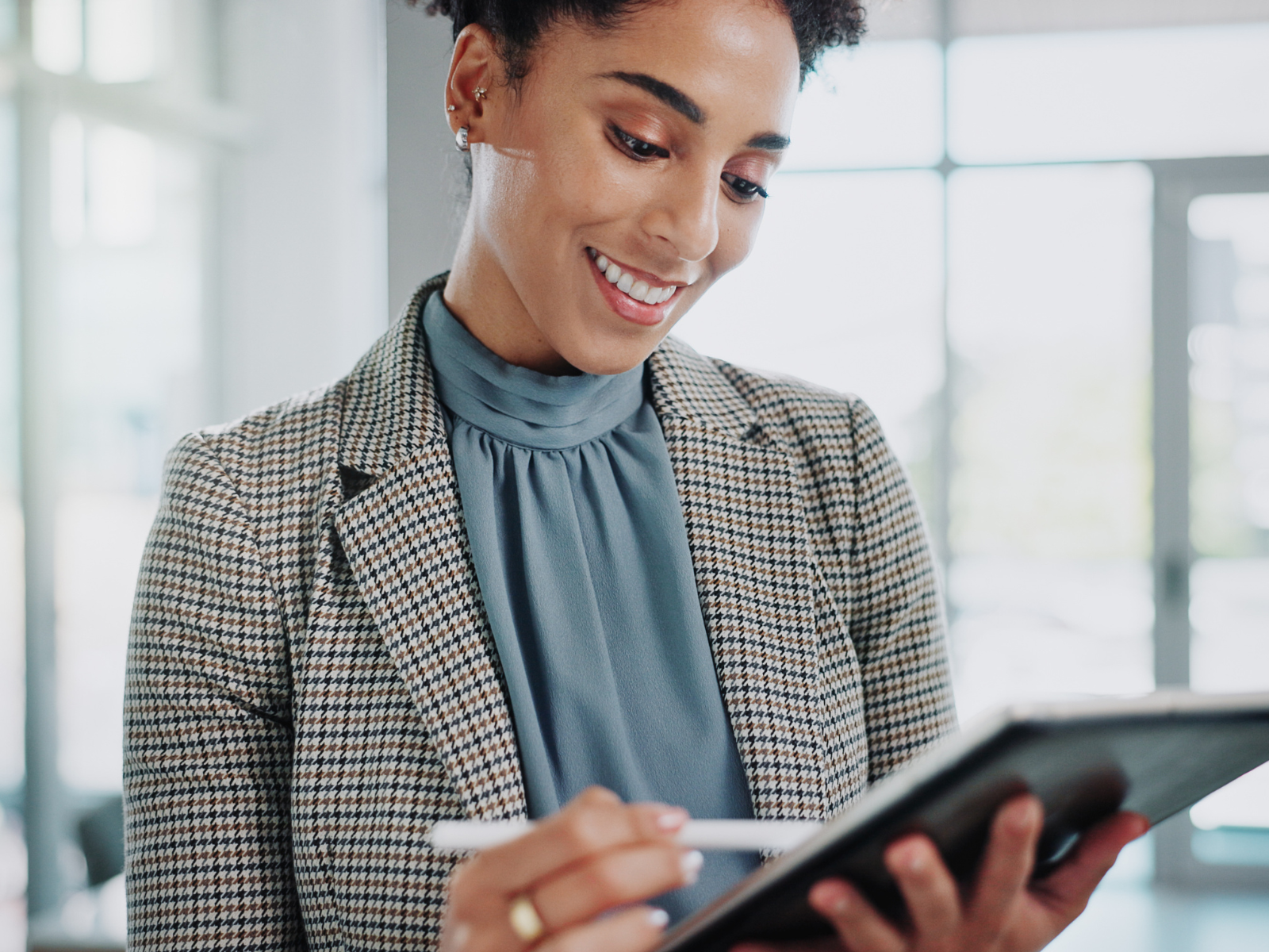 Professionally dressed woman reviewing data on her tablet